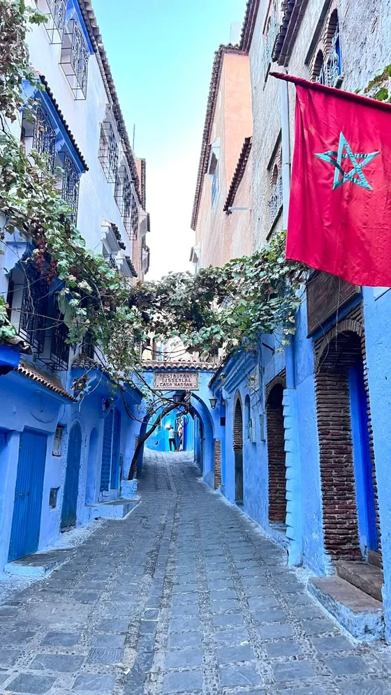 Ruela azul de Chefchaouen com a bandeira do Marrocos, Marrocos