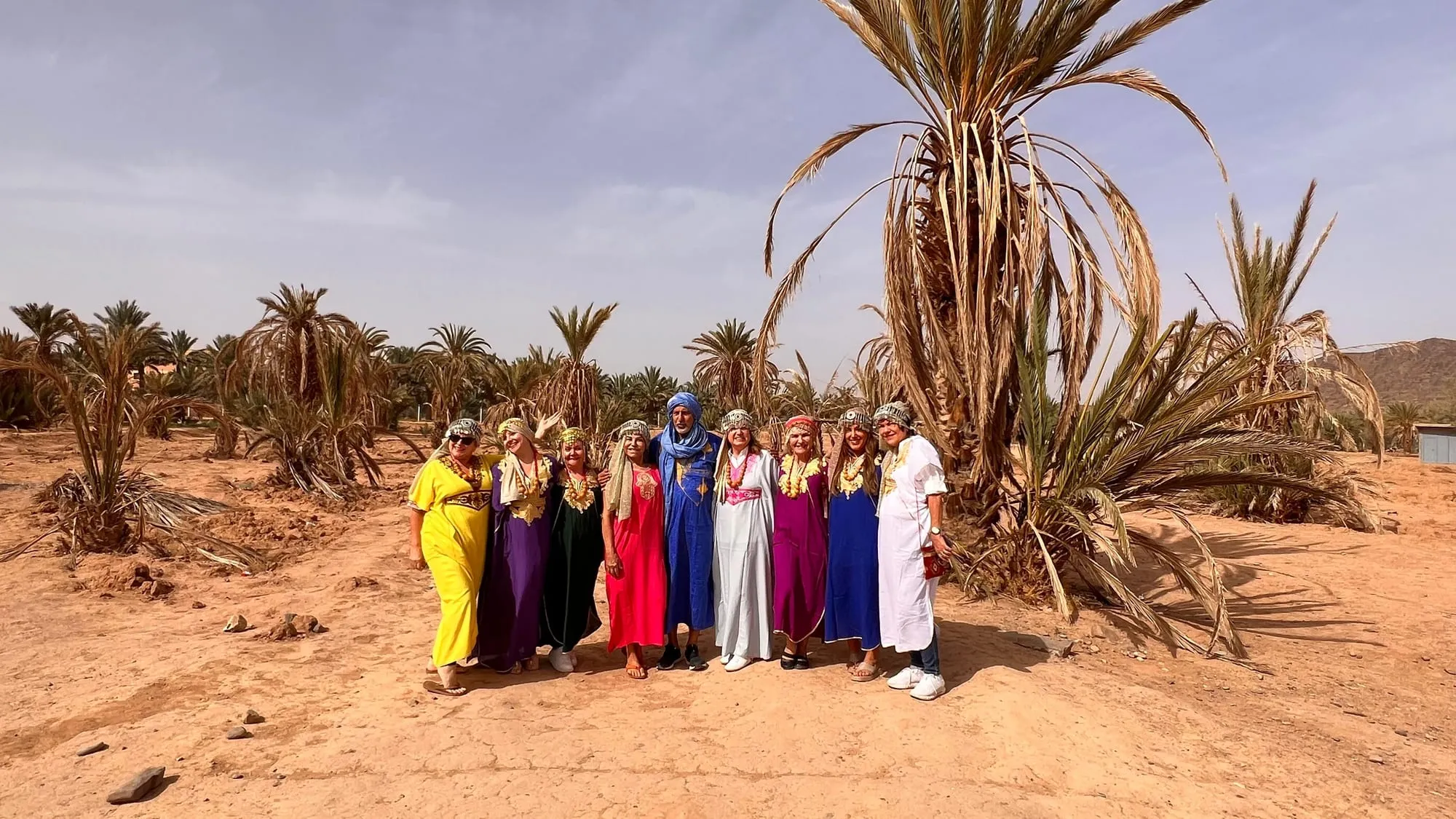 Grupo de viajantes num oásis de palmeiras no Marrocos